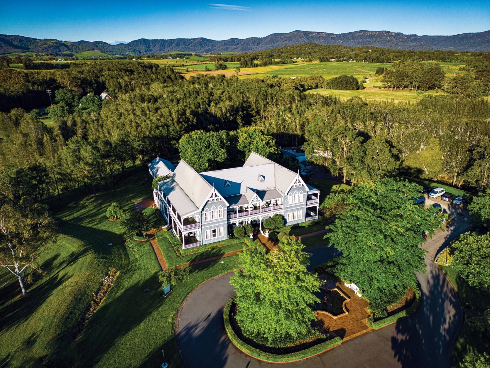 The Convent Hunter Valley from the air at golden hour: the building, the fountain forecourt, the drive and the range