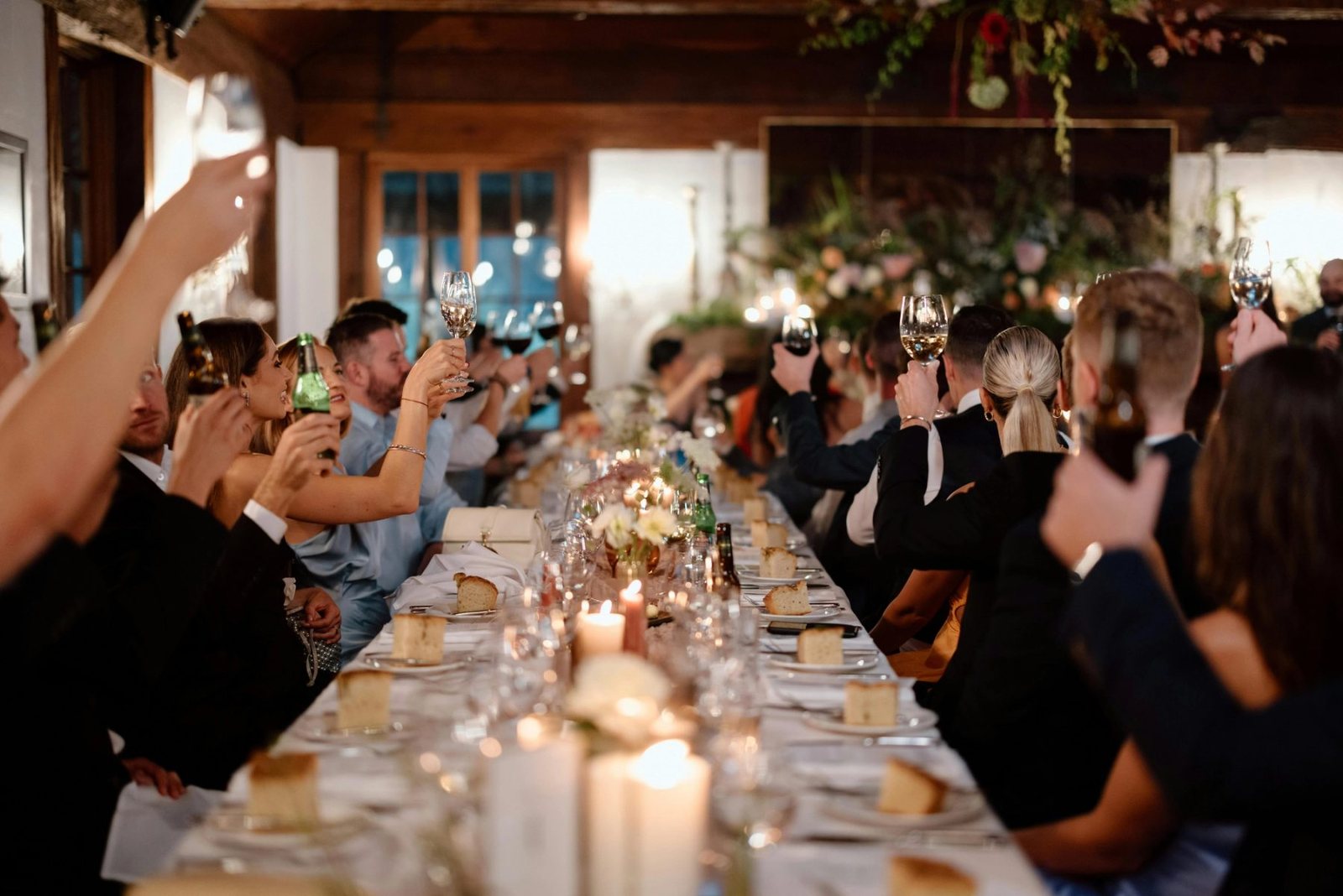 Guests raising glasses along a candlelit table inside Circa 1876
