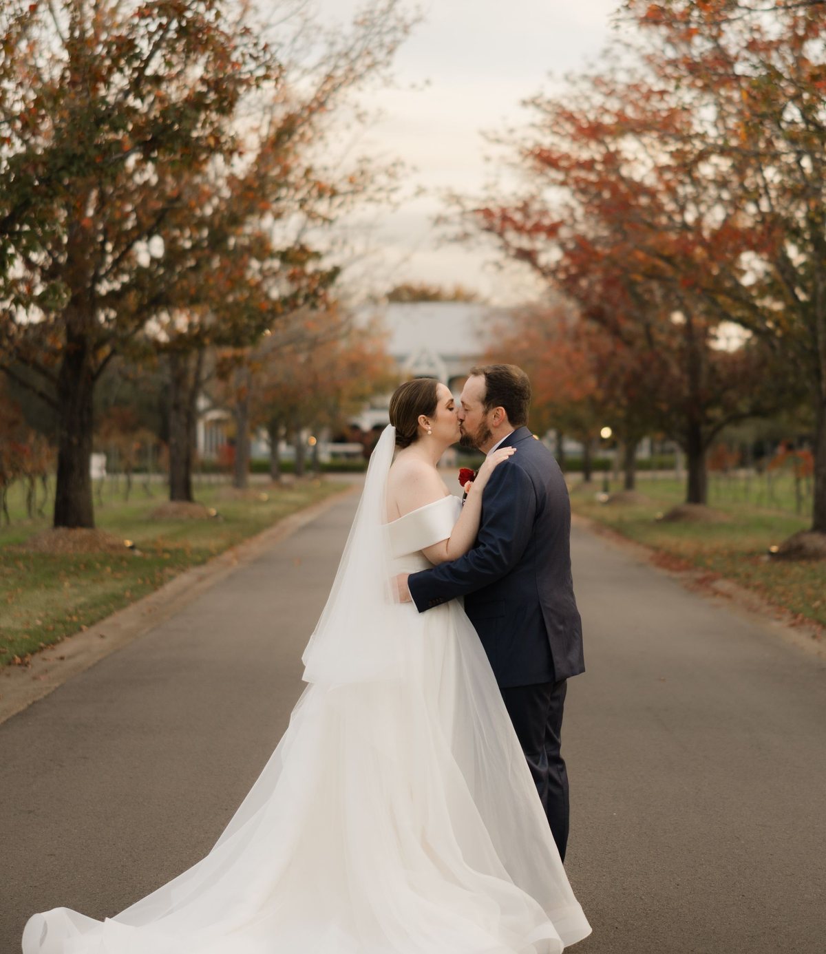 A couple kissing on the plane-tree driveway with the Convent behind